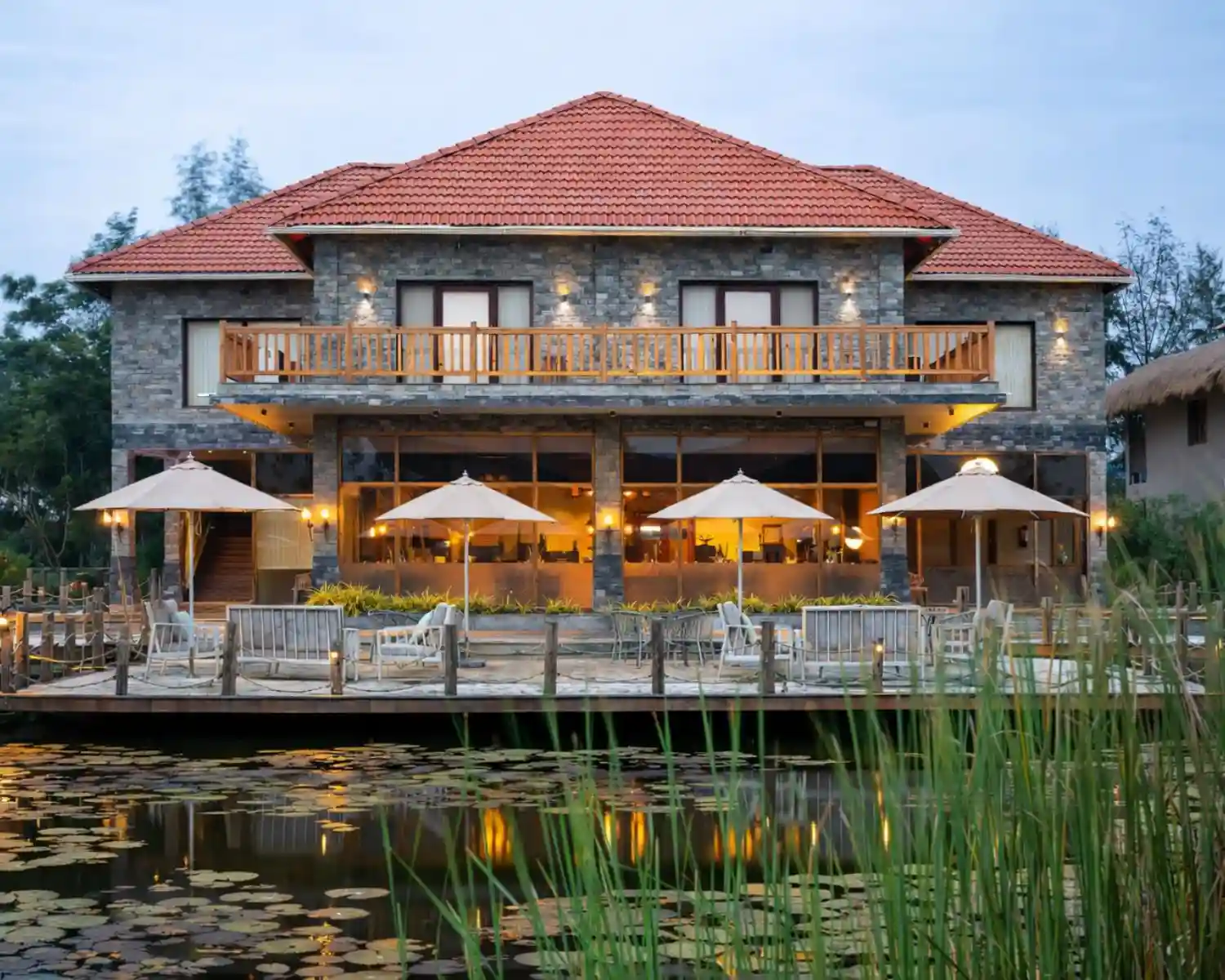 Hotel Sonar Bangla luxury resort in Sundarbans showing swimming pool, main building, and premium seating area.